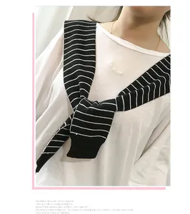 Detail view of a black and white striped knitted shawl collar styled on a white T-shirt