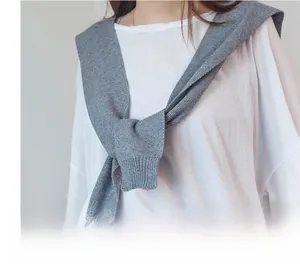 Detail shot of grey knitted fake collar shawl knotted over a white long sleeve shirt