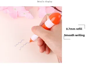 Vista detallada de un bolígrafo cápsula naranja de 0,7 mm escribiendo suavemente en papel
