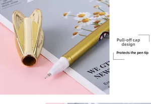 Macro shot of gold dart pen with heart-shaped cap and protected fine tip for students