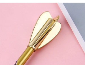 Detailed close-up of golden arrow-shaped neutral pen with realistic fletching tail detail