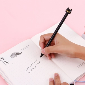 Cute black cat cartoon gel pen 0.5mm with golden eyes being used for writing on a notebook