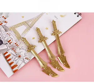 Detail of three golden sword-shaped pendant pens with intricate handle textures