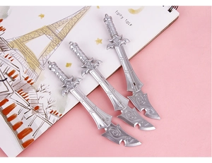 Detailed view of silver sword-shaped gel pens with intricate vintage carvings on a desk