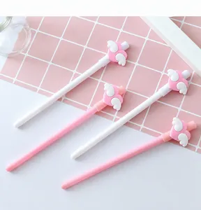 Close-up of four cute heart wing gel pens in pink and white on a desktop background