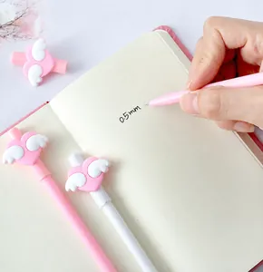 Close-up of 0.5mm gel pens featuring 3D pink hearts and white wings on the caps
