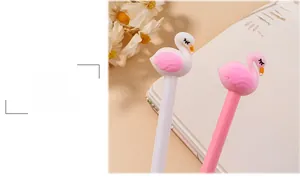 Close-up of cute pink and white swan pens on a desk with a notebook and flowers