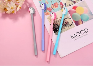 Flat lay of four colorful unicorn gel pens with 3D toppers on pink background
