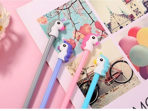 Close-up of four colorful cartoon unicorn gel pens on a soft pink aesthetic background