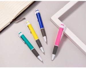 Set of four retractable ballpoint pens in cyan, yellow, blue, and pink on an office desk