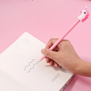 Pink unicorn gel pen with soft silicone topper for school student writing on notebook