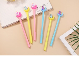 Close-up of cute cartoon unicorn sitting on moon ornaments atop colorful gel pens set