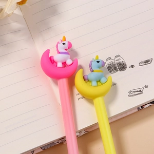 Cute cartoon unicorn moon gel pens in pink and yellow on an open notebook stationery