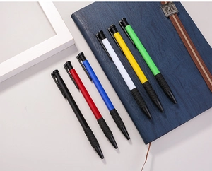 Set of six colorful retractable pens with textured soft rubber grips on a blue notebook