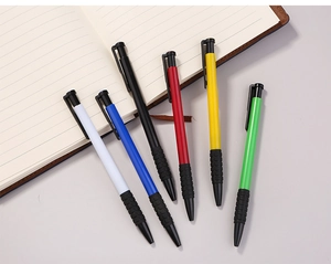 Detail of colorful retractable ballpoint pens with anti-slip grip on a lined notebook