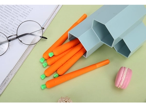 Creative carrot gel pens with leaf detail and blue honeycomb pen holder on desk