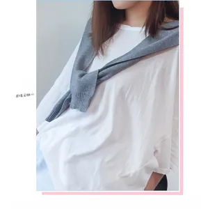 Close-up of a white cotton T-shirt layered with a grey knitted shawl in Korean style