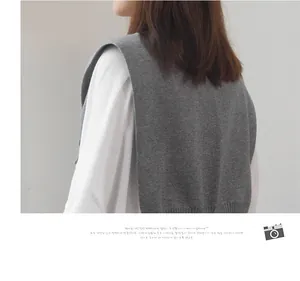 Detail of grey knitted shawl styled over a white shirt, showcasing fine knit texture and fit