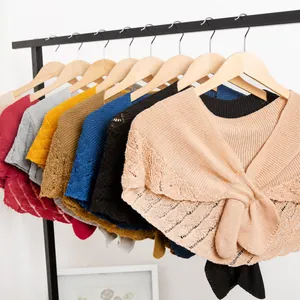 Detail of crochet knit shawls showing delicate leaf patterns and diverse color options