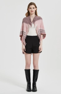 Détail d'un poncho en tricot color block avec motifs ondulés et franges longues