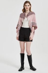 Détail du châle en tricot rose et violet avec motifs en zigzag et finitions à franges