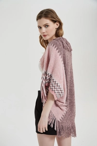 Détail d'un poncho en tricot rose et violet avec des franges et des motifs jacquard