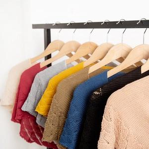 Short sleeve hollow knit shawls in multiple vintage colors hanging on wooden hangers
