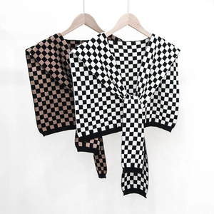 Checkboard knit shawl faux collars in black-white and black-brown on a wooden hanger