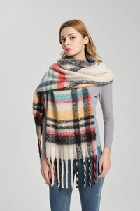 Dettaglio di una sciarpa a quadri oversize con spesse frange in caldi colori invernali