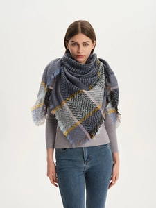 Detail of a thick plaid scarf with long fringes and coarse woven texture for winter