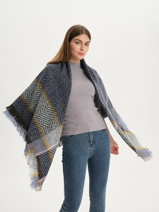 Macro shot of thick winter plaid scarf with fringed edges in grey-blue and yellow colors