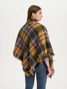 Detail of checkered shawl with ginger yellow tones and fluffy fringe edges