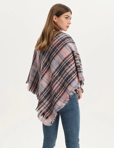 Detail of pink and blue plaid shawl with soft fringe trim and oversized knit texture