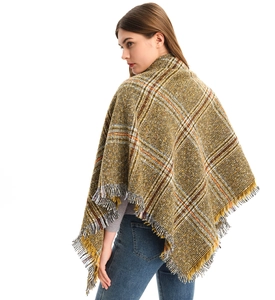 Detail of autumn checkered shawl featuring yellow fringes and soft wool blend texture