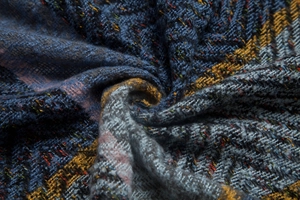 Close-up of thick checkered knit scarf showing colorful tweed texture and soft fabric layers
