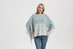 Close-up of the light blue knitted texture and fringe detail on this striped poncho