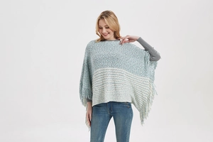 Detail of light blue striped knit poncho featuring elegant tassel fringe hem for women