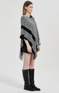 Detail eines schwarz-weißem Ponchos mit Hahnentrittmuster und weichem Fransenbesatz