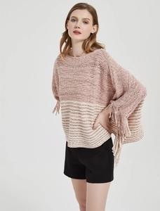 Detail of pink and white striped knit poncho with fringe edges and soft texture