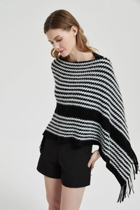 Detail von schwarz-weiß gestreiftem Strickponcho mit Fransen und weicher Materialstruktur