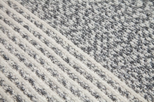 Close-up of grey and white knit fabric showing vertical rib texture and thick yarn quality