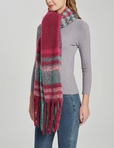 Close-up of thick knitted plaid scarf with colorful oversized tassels and warm texture