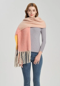 Detail van kleurgeblokte gebreide sjaal met lange franjes in roze, geel en beige