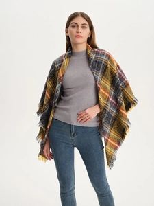 Detail of multi-color plaid scarf featuring thick textured knit and soft tassel edges
