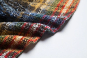 Detailed close-up of thick multi-color plaid scarf fabric showing soft wool texture