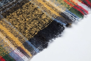 Close-up of colorful checkered scarf fabric with soft natural fringe edges