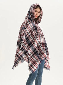 Close-up of red and blue plaid hooded shawl with soft knit texture and fringe detail