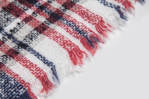 Detailed view of red and blue checkered shawl showing woven texture and fringe trim