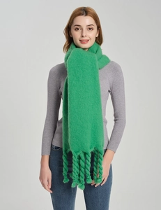 Detail of chunky emerald green knit scarf with braided fringe and thick texture