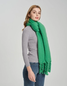 Detail shot of bright green knit scarf featuring unique thick rope tassel edge design